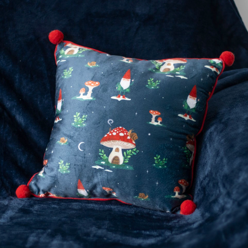 Square Gnome Print Cushion with Pom Poms on a chair