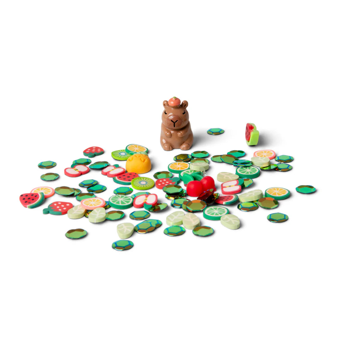 Small figurine of a capybara surrounded by colourful plastic fruit slices on a white background