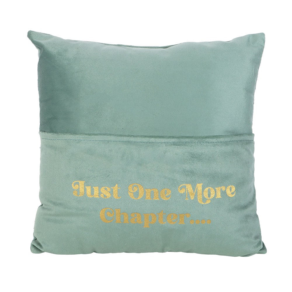 Green pillow with 'Just One More Chapter...' text on a white background