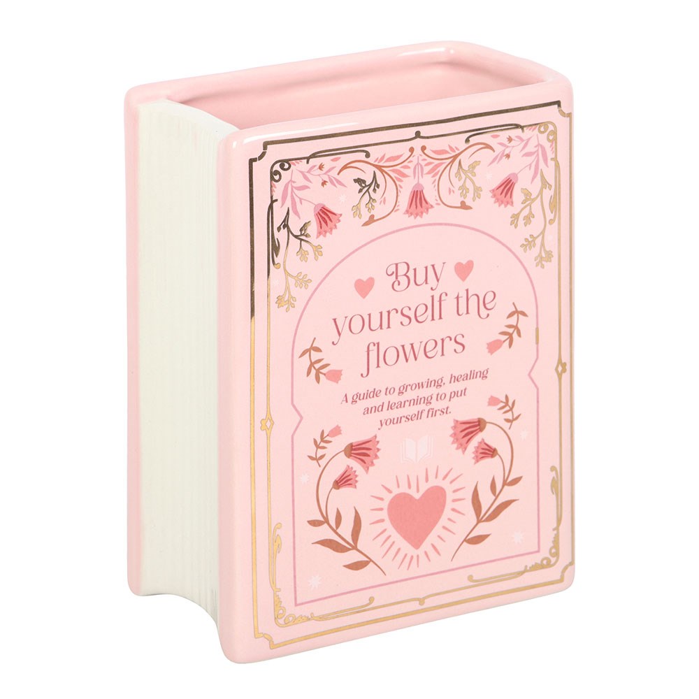 Pink book-shaped vase container with floral design and text on a white background