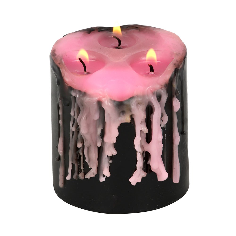 Small Pink Vampire Tears Pillar Candle black candle with pink wax inside lit
