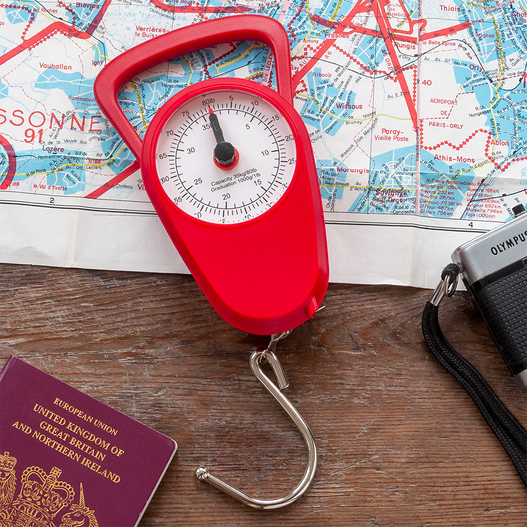 Mechanical travel scales in red, with built-in tape measure.