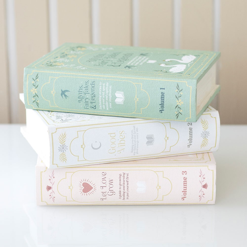 Stack of decorative book boxes with pastel covers on a white surface