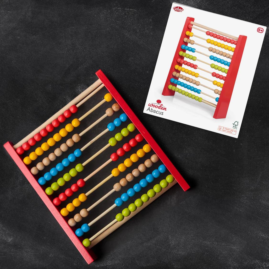 Wooden abacus with colorful beads on a black surface, next to its packaging.