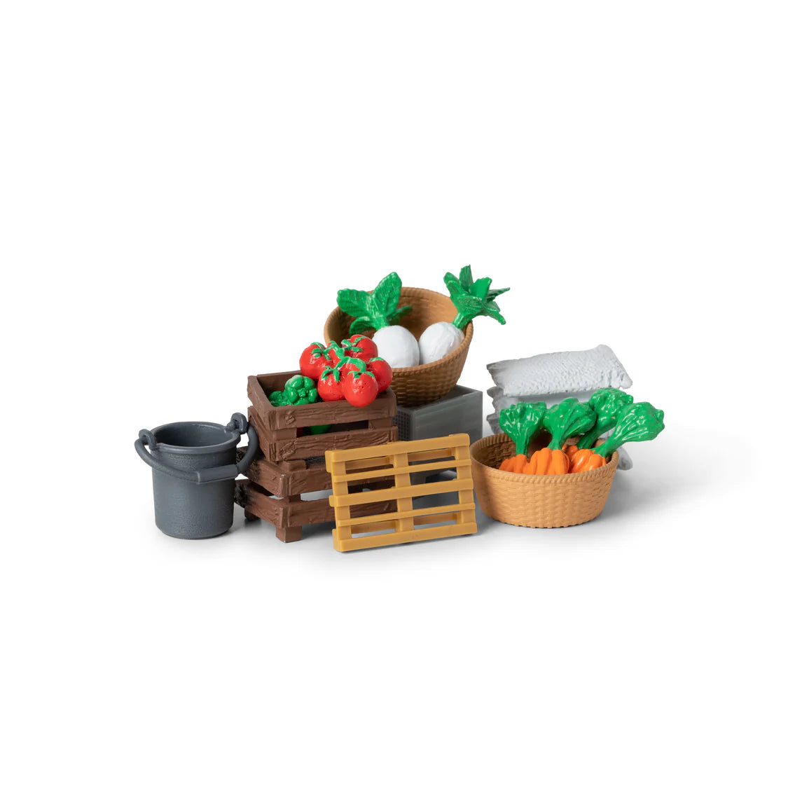 Set of toy vegetables and gardening items on a white background