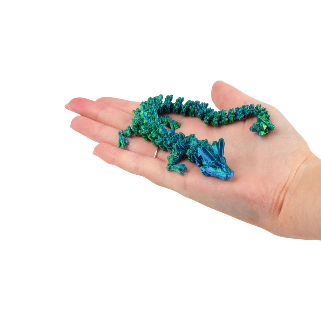 Hand holding a small blue and green dragon on a white background