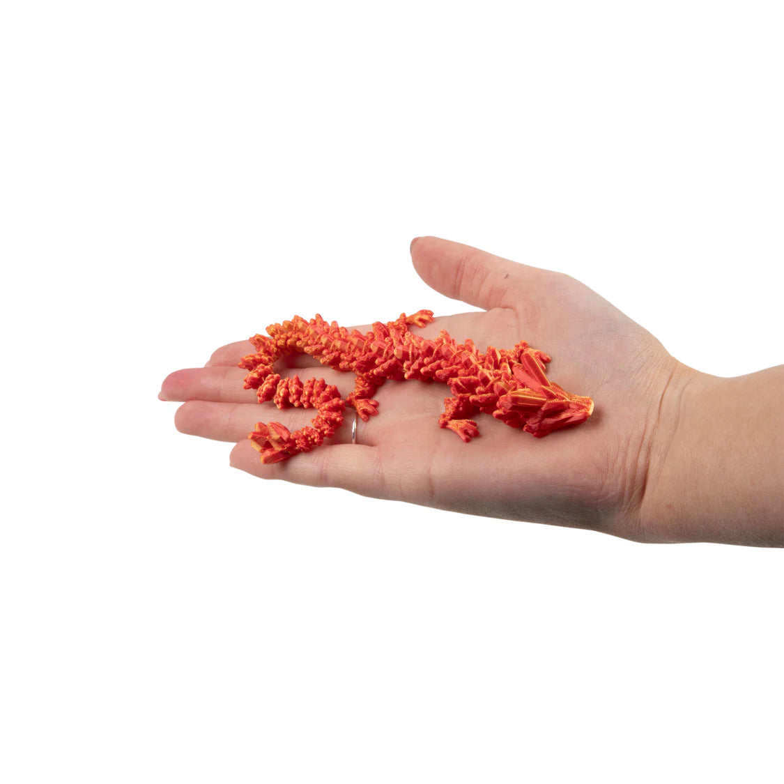 Hand holding a small orange dragon on a white background
