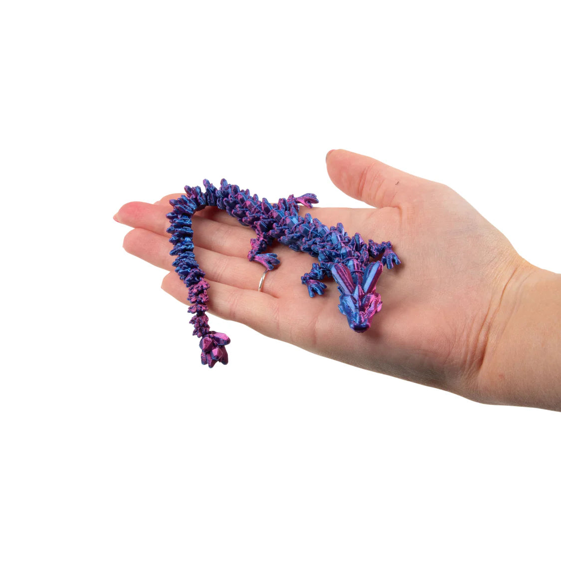 Hand holding a blue and purple dragon against a white background