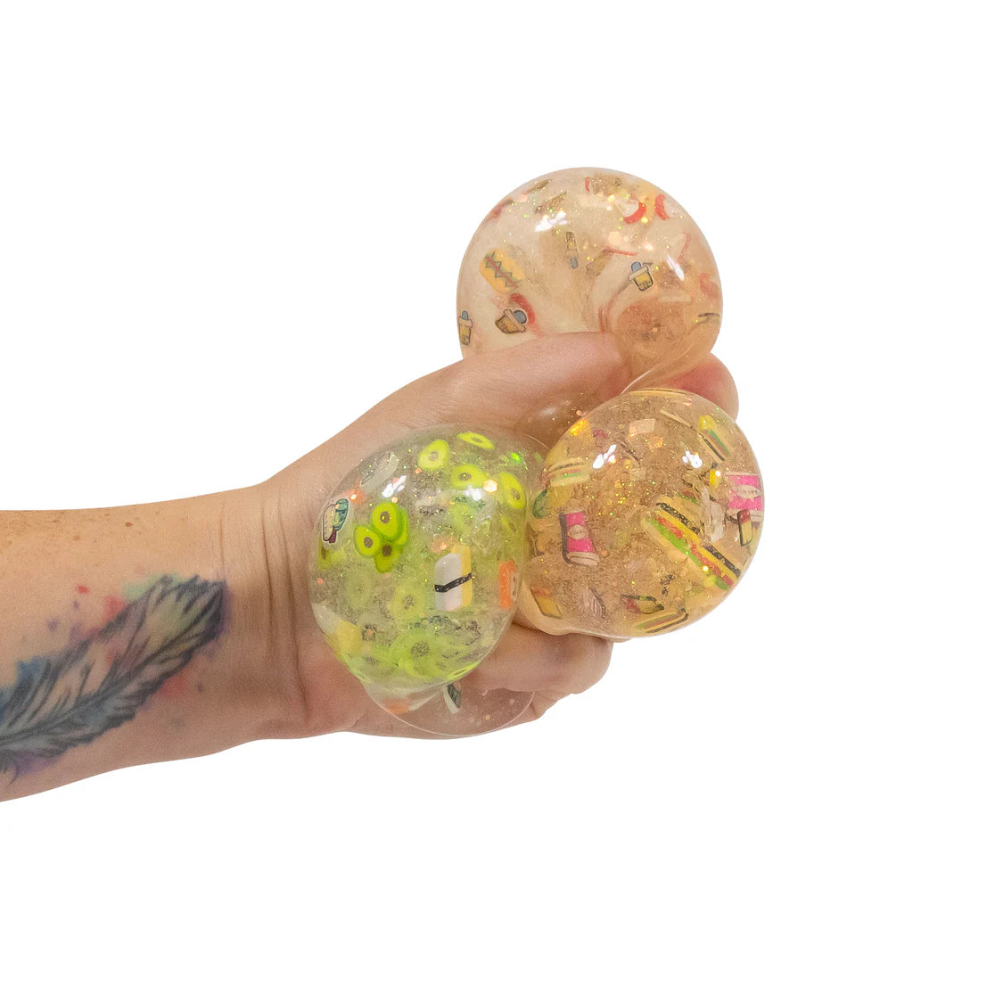 Hand holding a transparent stress ball with colorful beads on a white background
