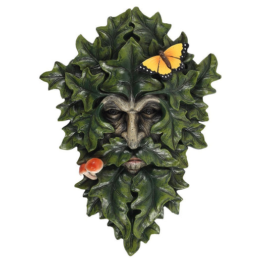 Decorative green man wall plaque with leaf design and small figurines on a white background