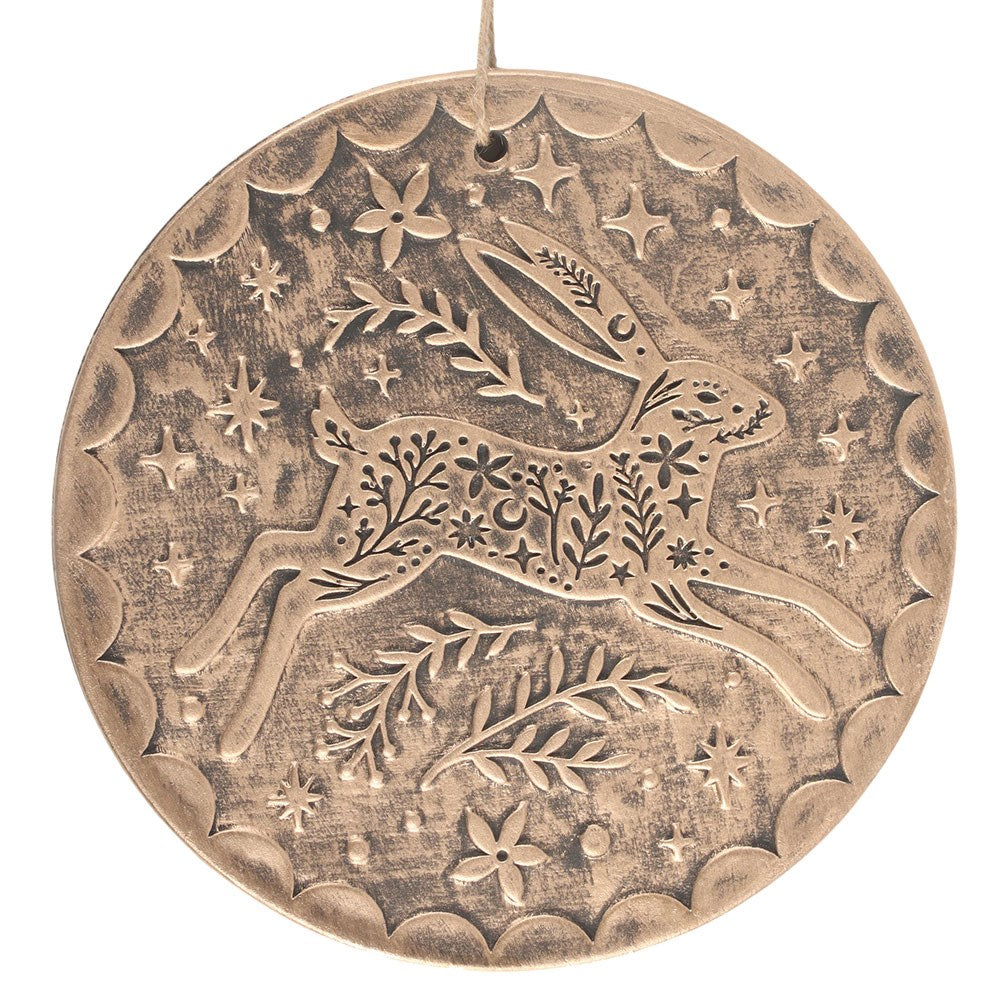 Decorative bronze terracotta ornament with hare and floral patterns on a white background
