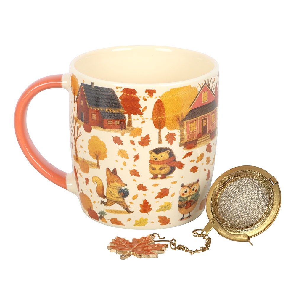 Mug with autumn-themed design and tea infuser on a white background