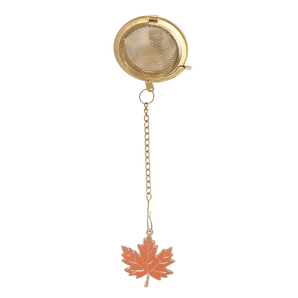 Gold tea infuser with a leaf charm on a white background