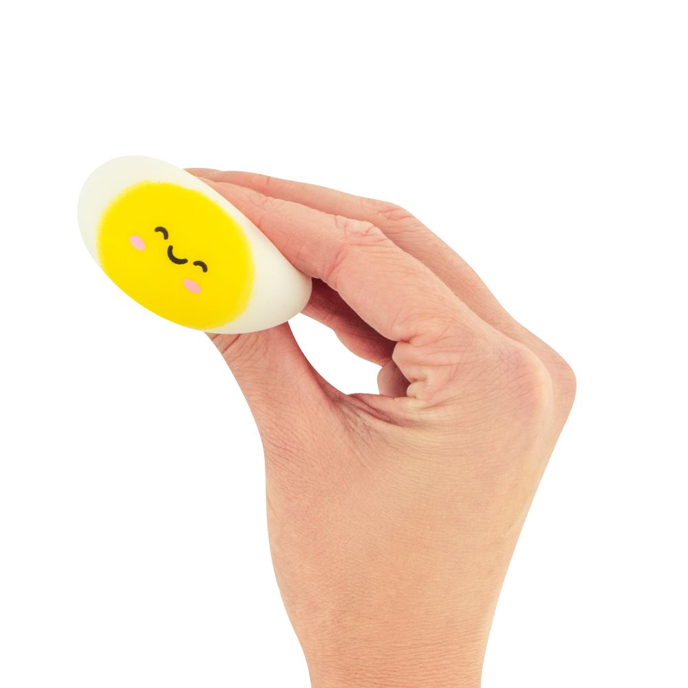 Hand holding a small round squishy dumplings with a smiley face on a white background