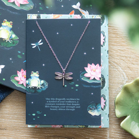 Dragonfly necklace on a decorative card with frog and lotus designs