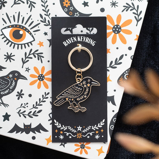 Raven keychain on a decorative card with Halloween-themed illustrations