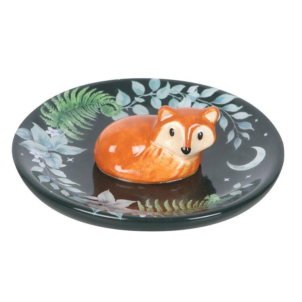 Decorative dish with a fox design on a black background with green and blue leaf patterns