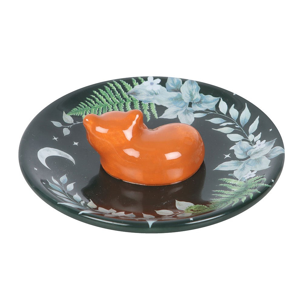 Orange fox on a decorative dish with floral patterns