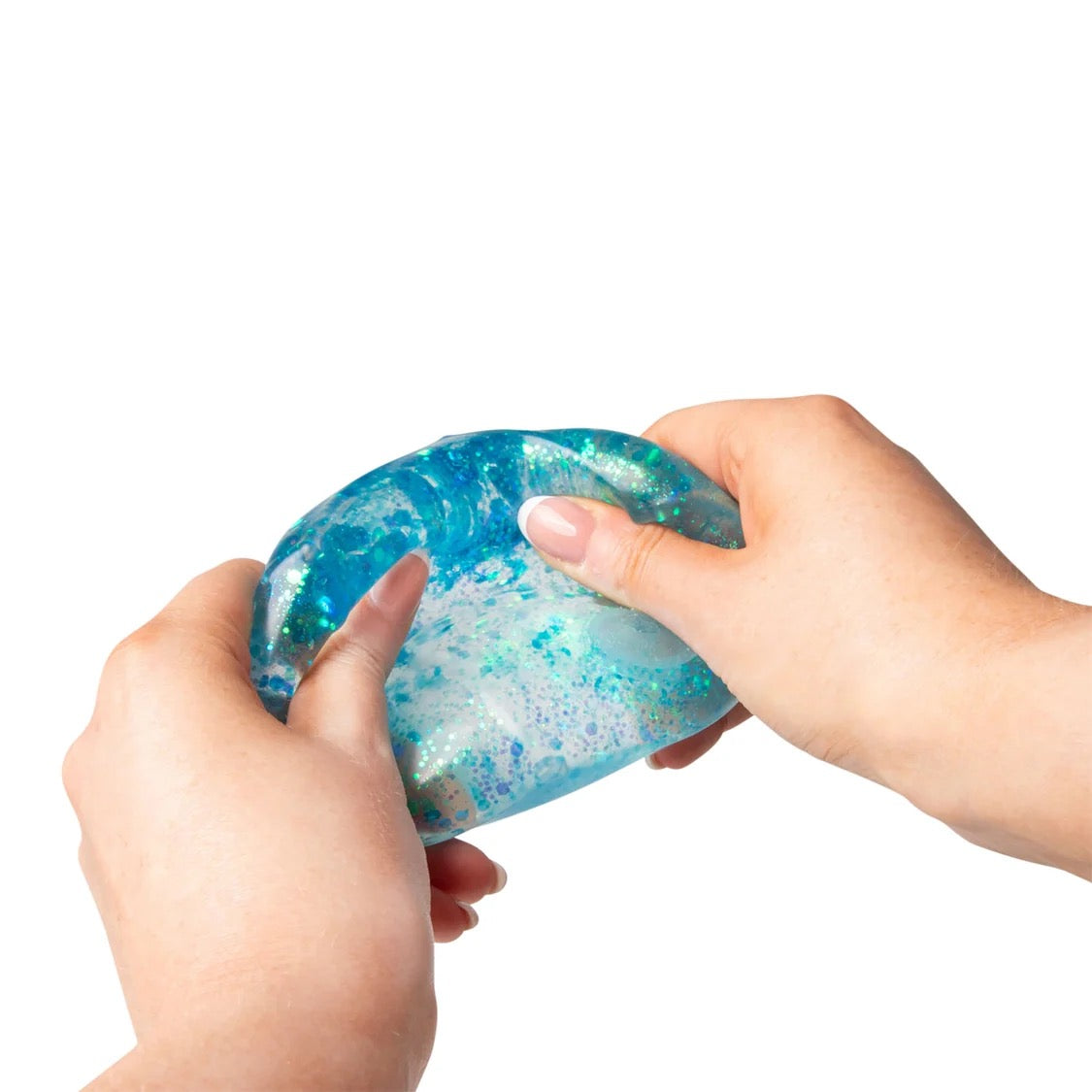 Hands holding a blue Scrunchems Glitter Cube against a white background
