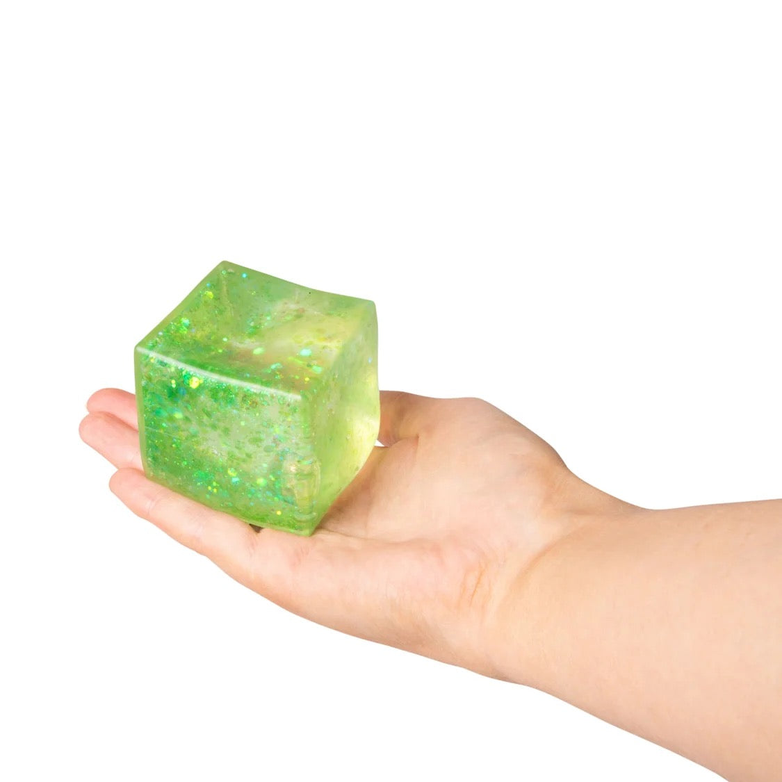 Hand holding a green Scrunchems Glitter Cube against a white background