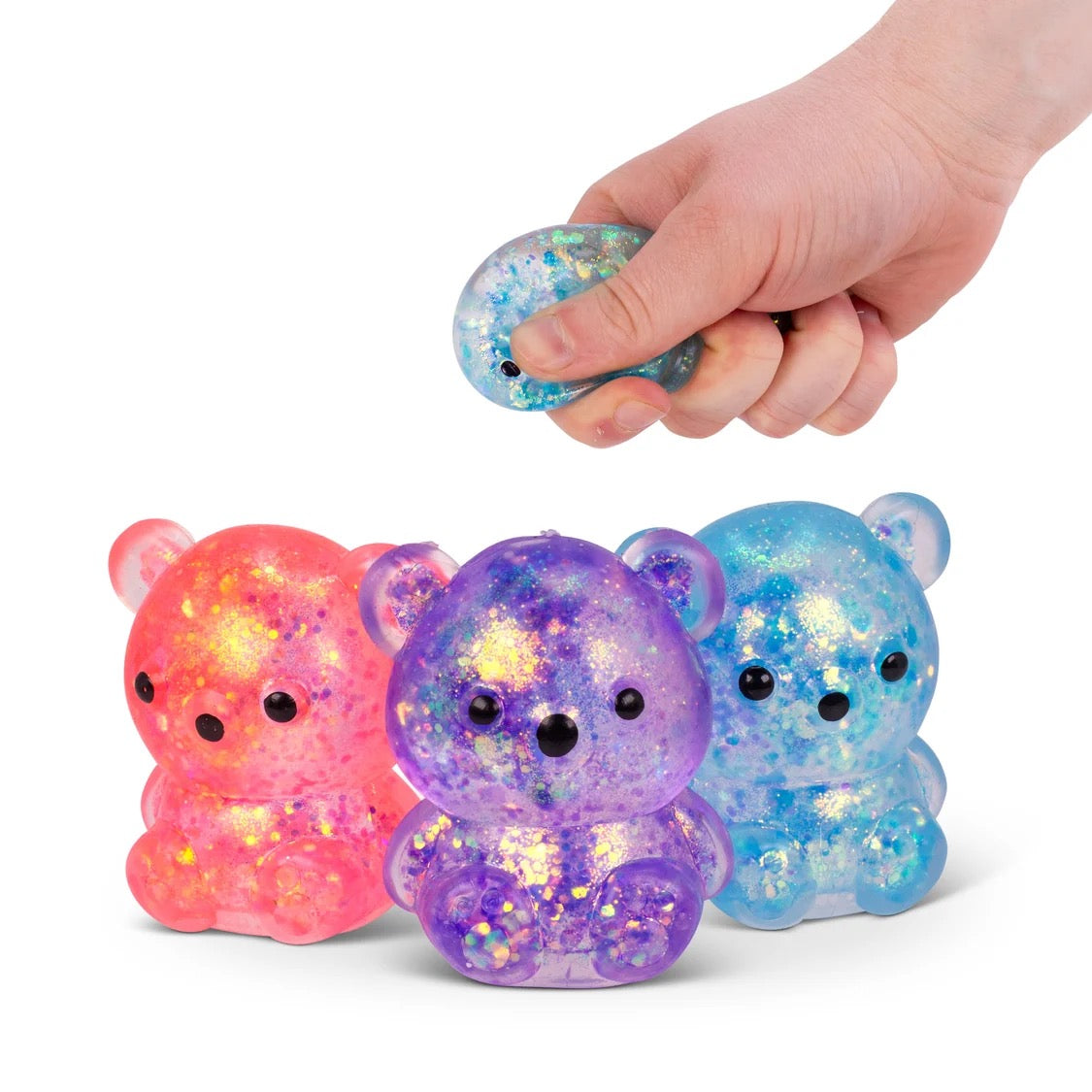 Three Scrunchems Squishy Sugar Bears with a hand holding one of them on a white background