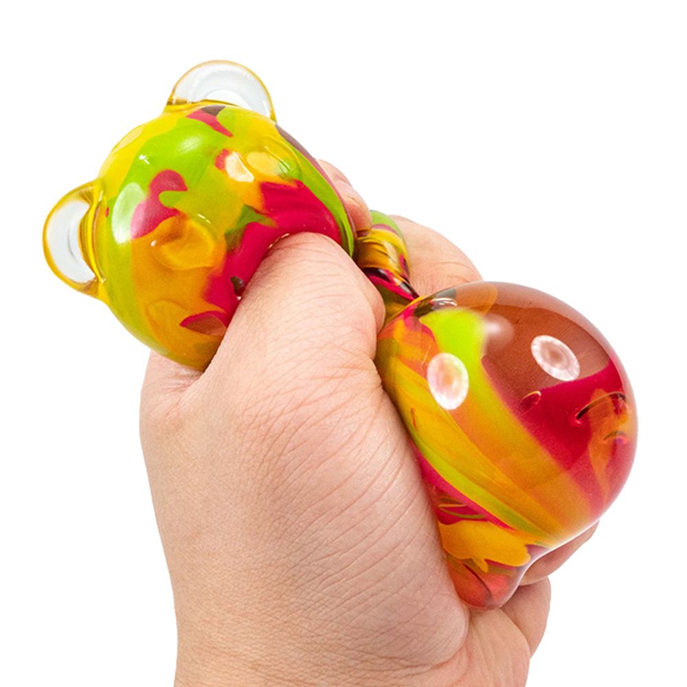 Colourful stress ink squish bear being held in a hand on a white background