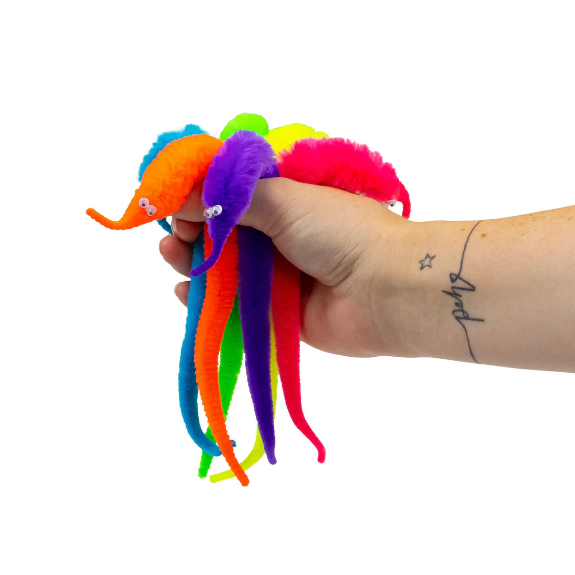 Hand holding colourful magic wriggler toys against a white background
