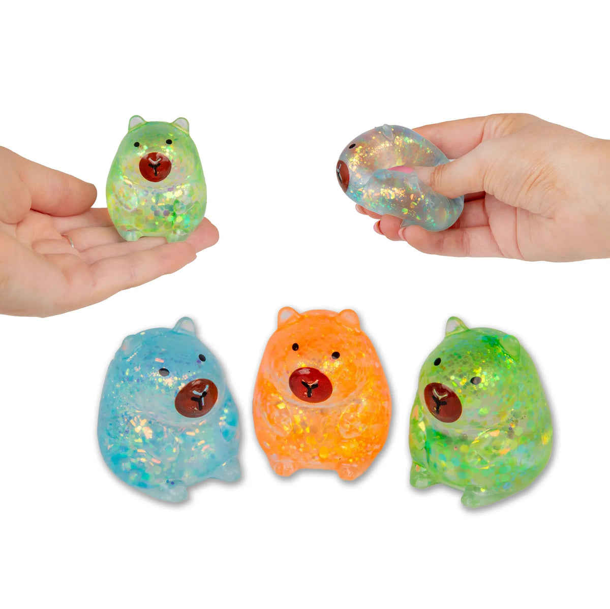Four colourful mini sugar capybaras stress balls held by hands on a white background