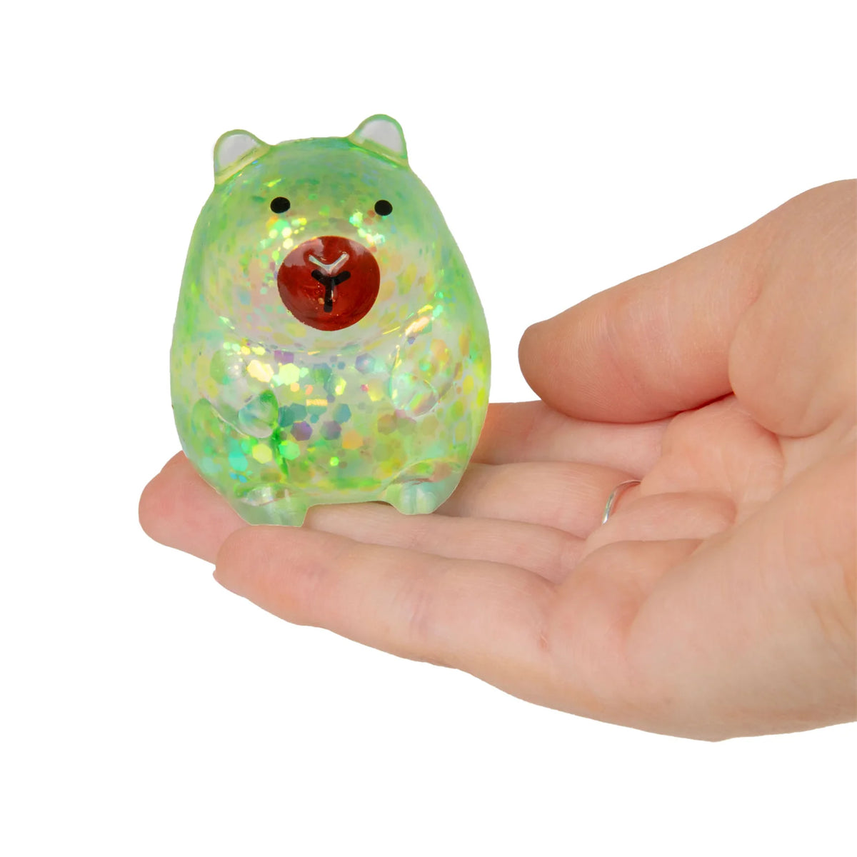Small, colorful mini sugar capybara held in a hand against a white background