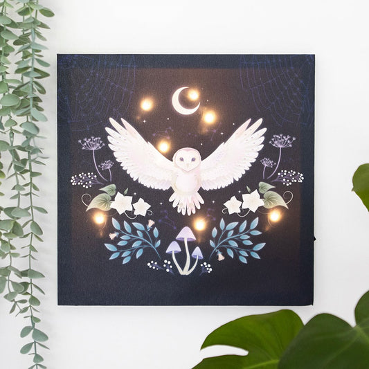 Decorative wall art with a white owl, flowers, and mushrooms on a dark background.