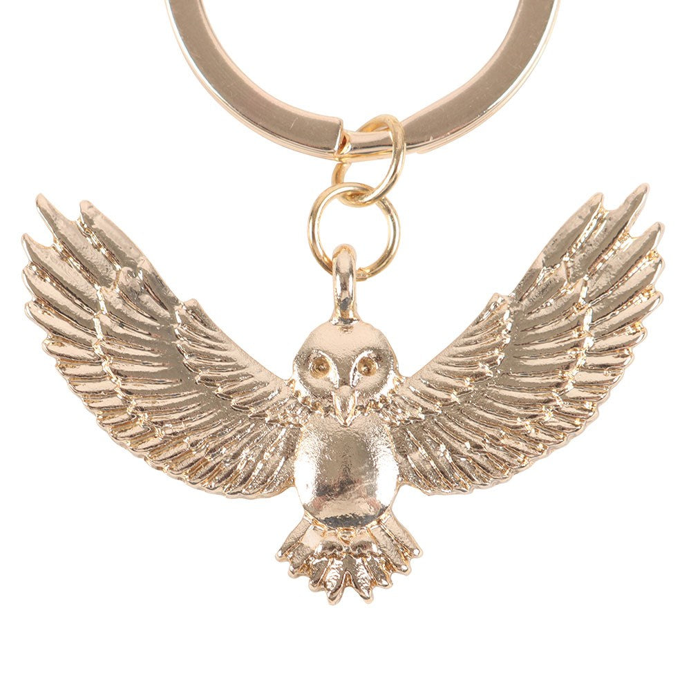 Gold owl keychain on a white background