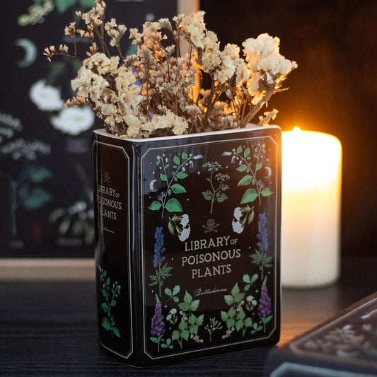 Decorative vase container with dried flowers labeled 'Library of Poisonous Plants' on a dark background.