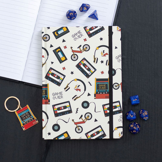 Notebook with retro-themed design on a black surface with dice and keychain.