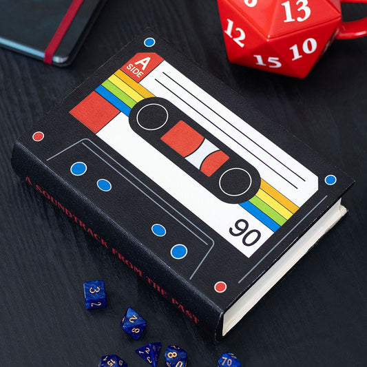 Book with cassette tape design storage box on a dark surface with dice around