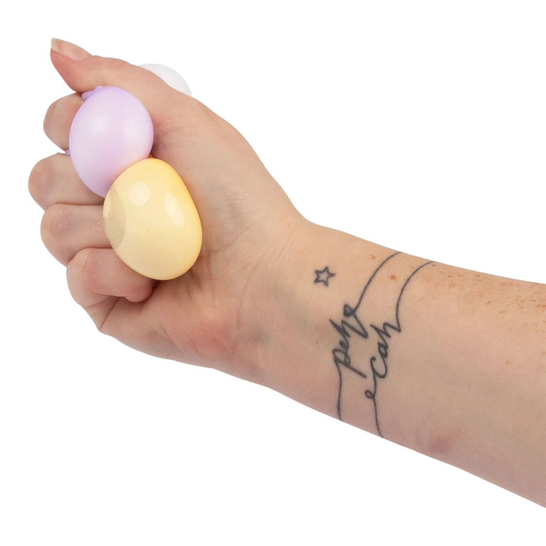 Hand holding scrunchems dumpling pastel-coloured against a white background