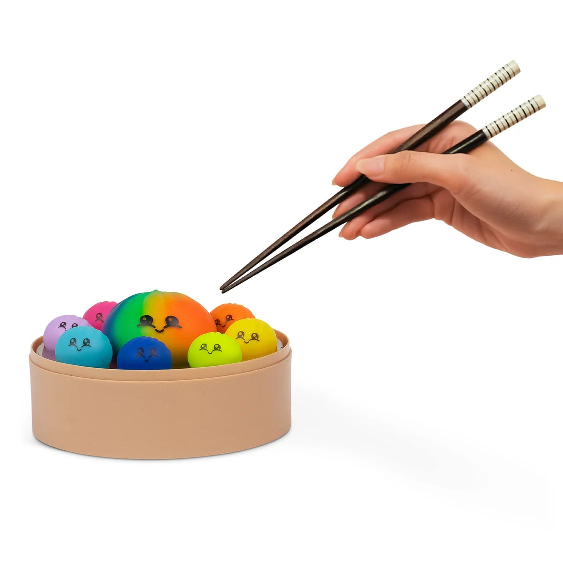 Colourful sensory fidget dumplings in a container with a hand holding chopsticks on a white background