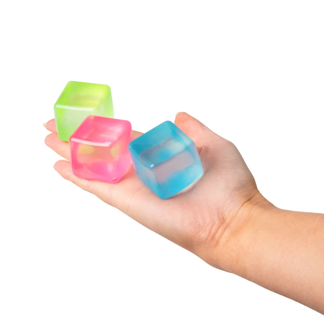 Hand holding three colourful sugar cubes on a white background