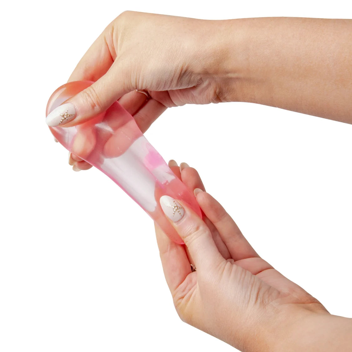Hand holding a pink sugar cube against a white background