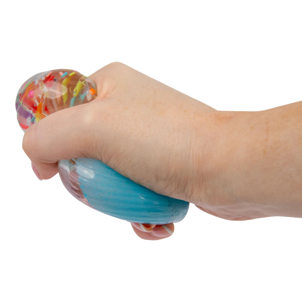 A hand squeezing a Scrunchems Sugar Cupcake shown against a plain white background.