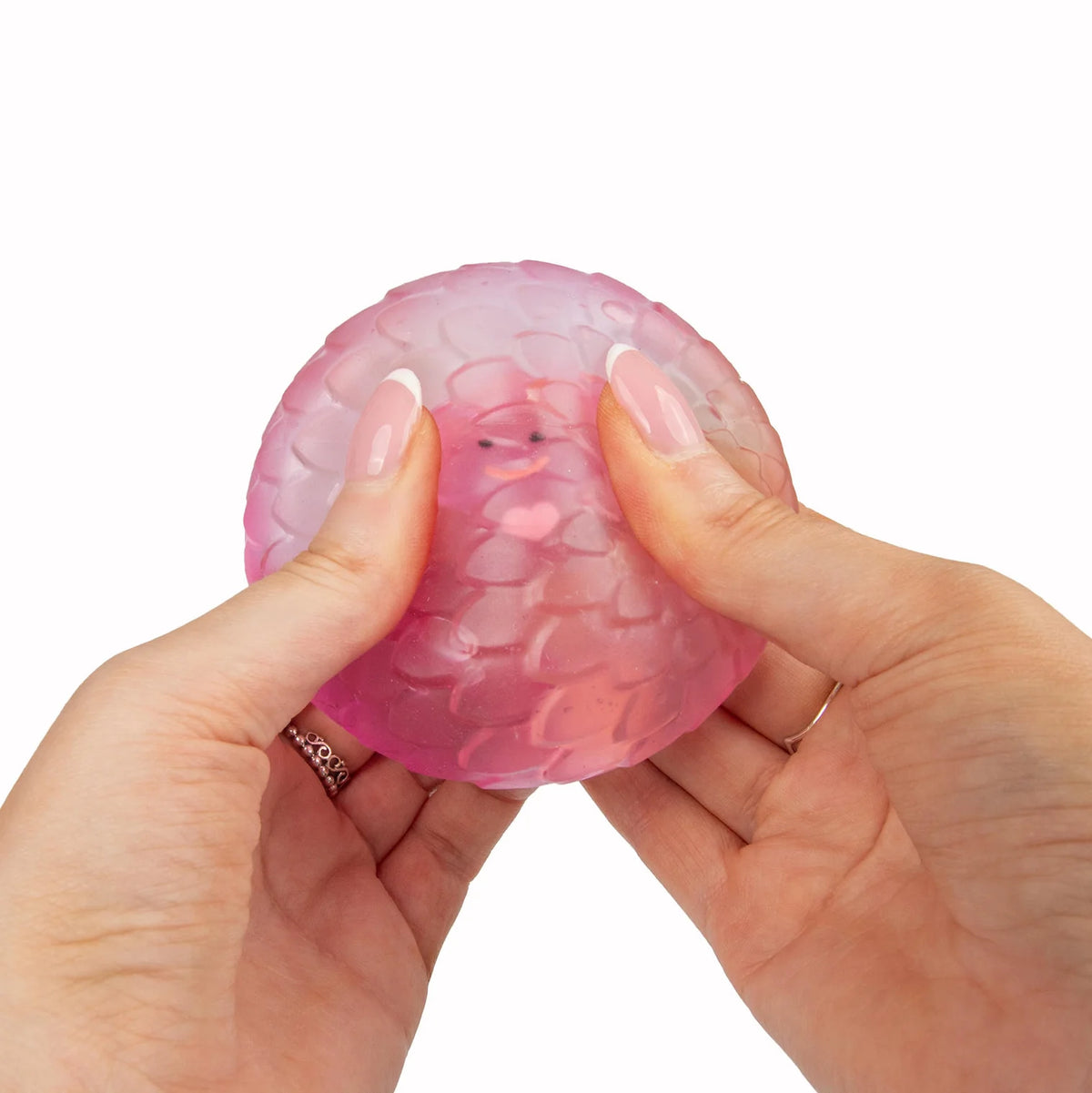 Pink Scrunchems Sugar Dragon Egg held between two hands on a white background