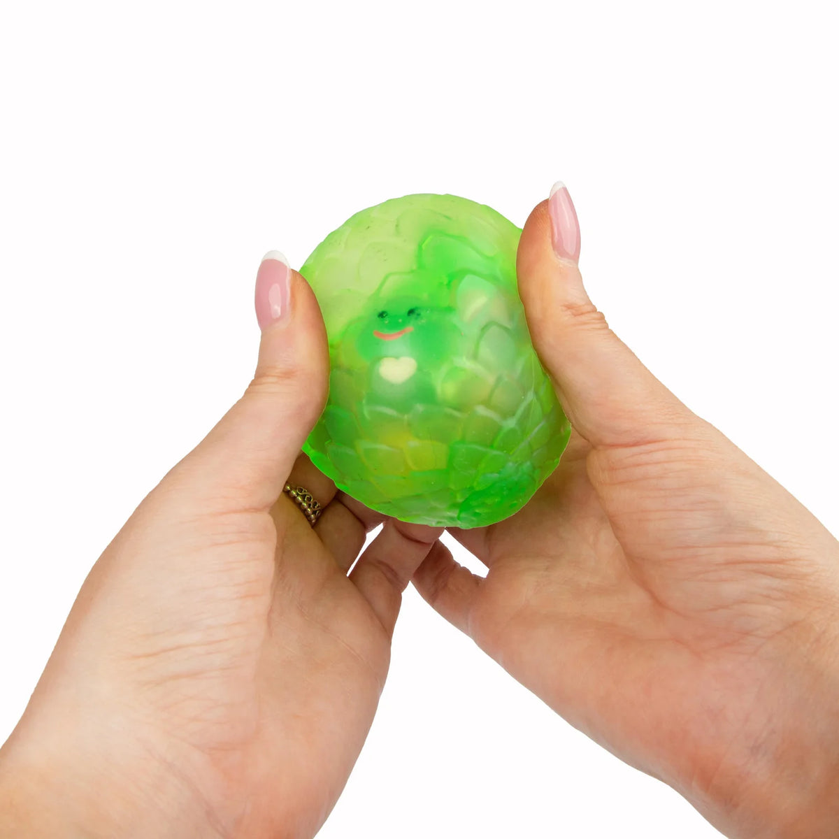 Green Scrunchems Sugar Dragon Egg held between two hands against a white background