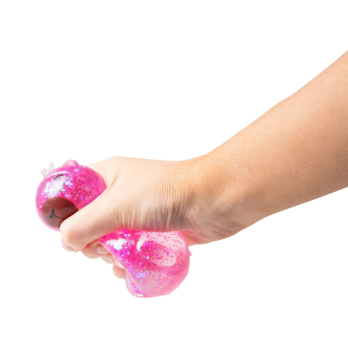 Hand squeezing a pink stress ball on a white background