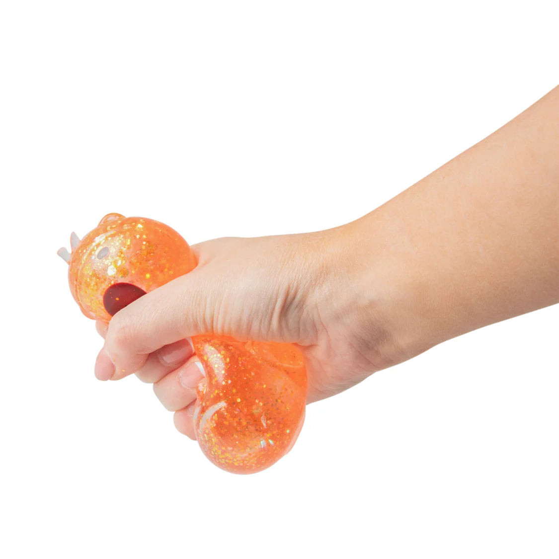 Hand holding a squishy orange toy with glittery texture on a white background