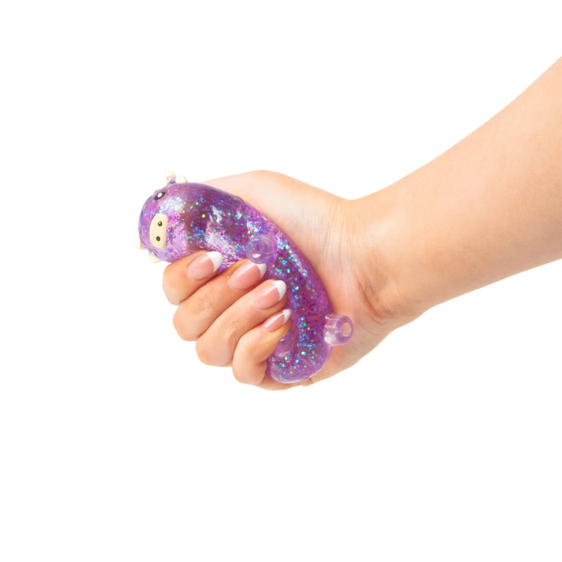 Hand holding a purple glittery sugar highland cow against a white background