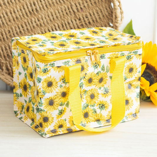 Yellow floral insulated lunch bag on a light surface with a woven basket in the background.