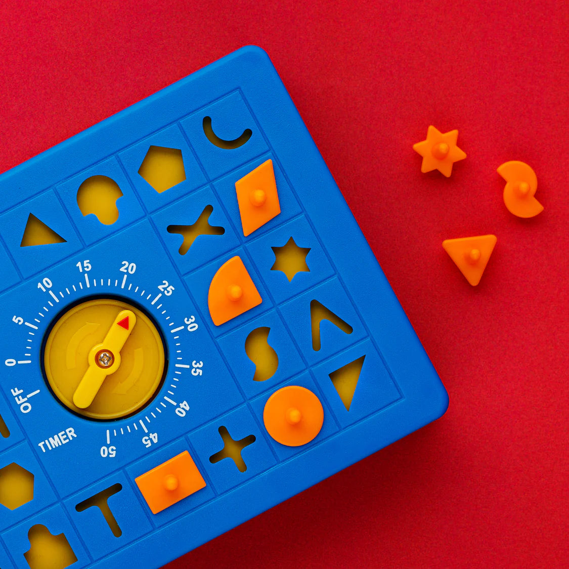 Colorful educational toy with shapes and timer on a red background