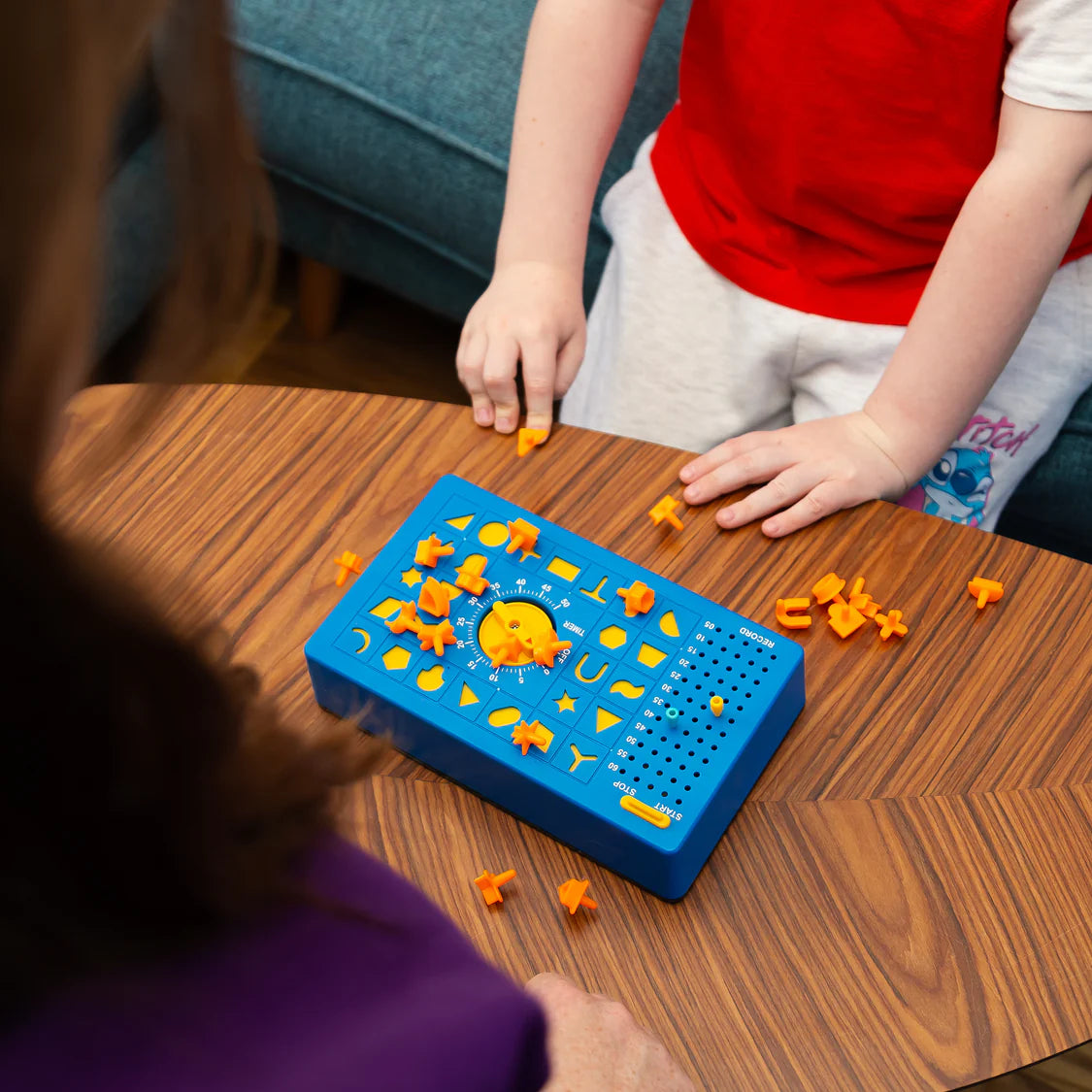 Children playing with a blue educational board game on a wooden table.