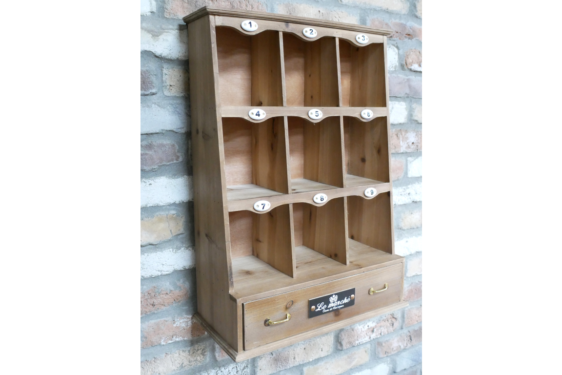Wooden shelf with multiple compartments against a brick wall.
