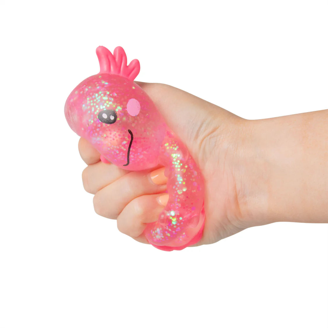 Hand holding a pink glittery squishy toy with a face on a white background