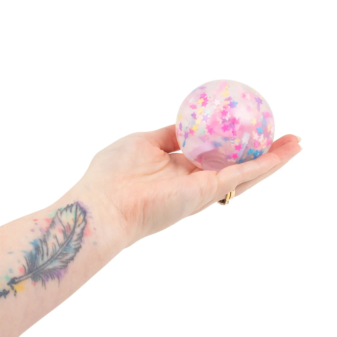Hand holding a colorful confetti-filled ball against a white background